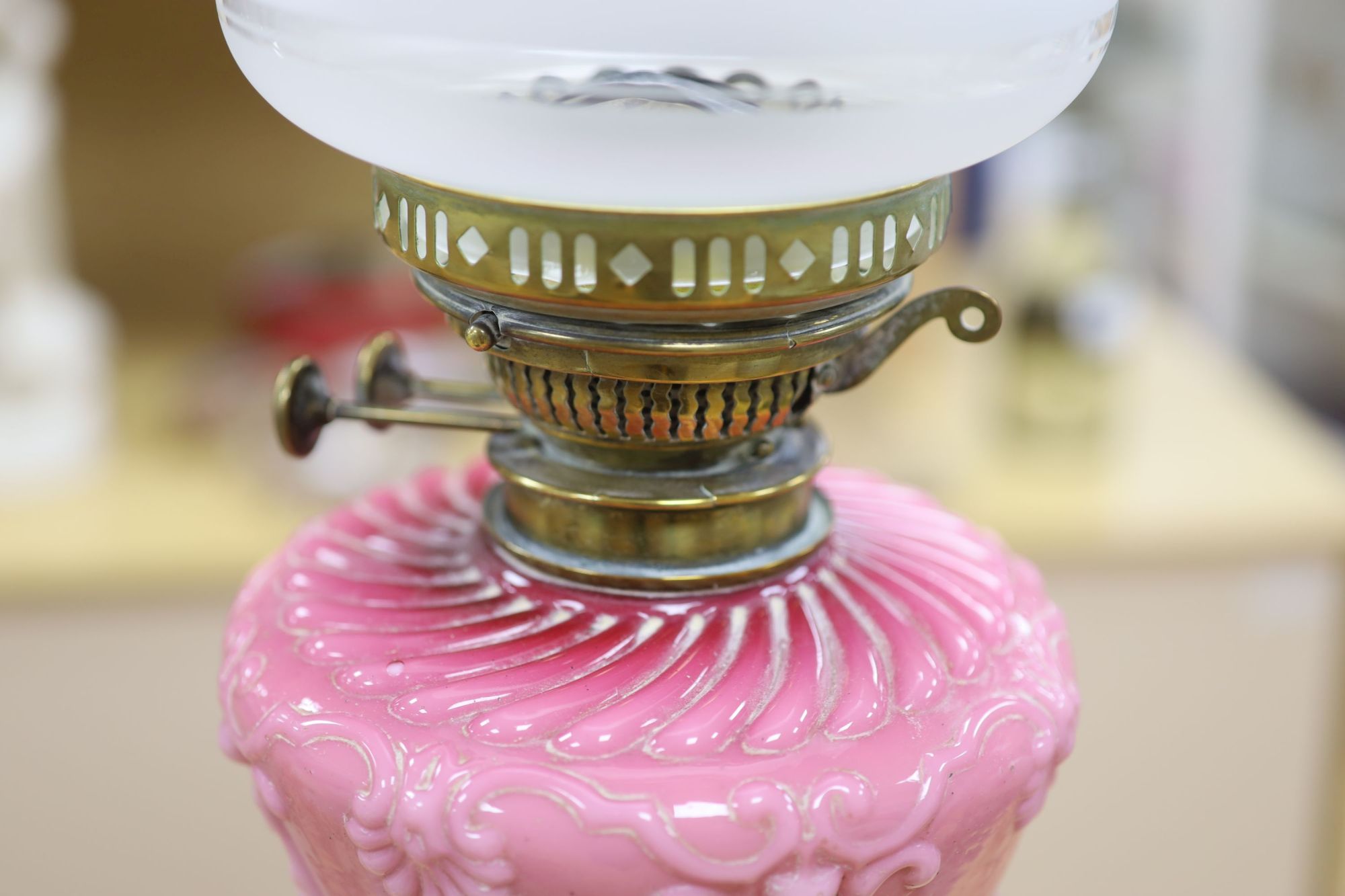 A late Victorian brass oil lamp with pink glass reservoir and a cranberry oil lamp